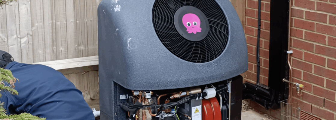 Grey heat pump being installed, with Octopus logo on the top, and front cover open to reveal mechanics within