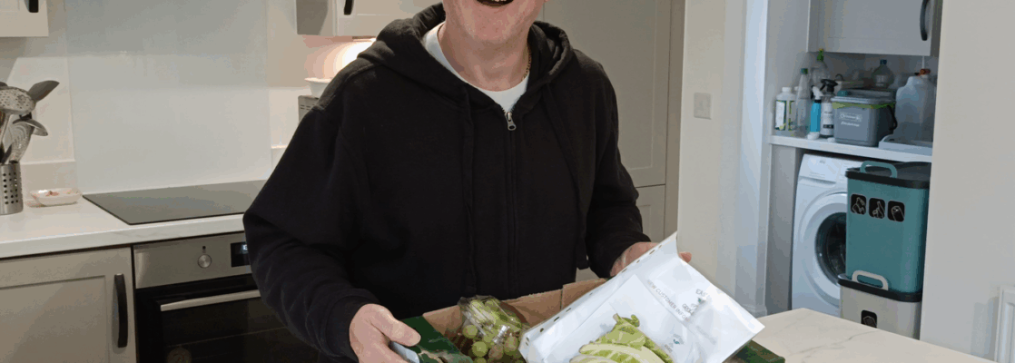 G3 holding a green cardboard local veg box from East Kent Growers